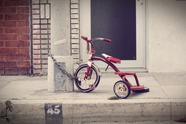 Un triciclo da bambino incatenato ad un palo